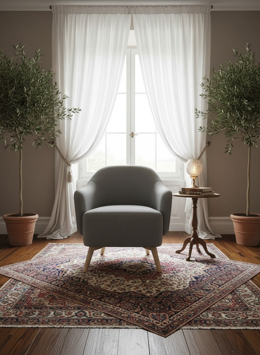 STYLNN® curved grey tub chair with tapered wooden legs in a bright, modern living room setting.