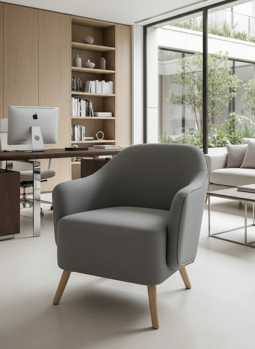 STYLNN®️ modern grey curved tub chair with tapered wooden legs in a bright home office setting.