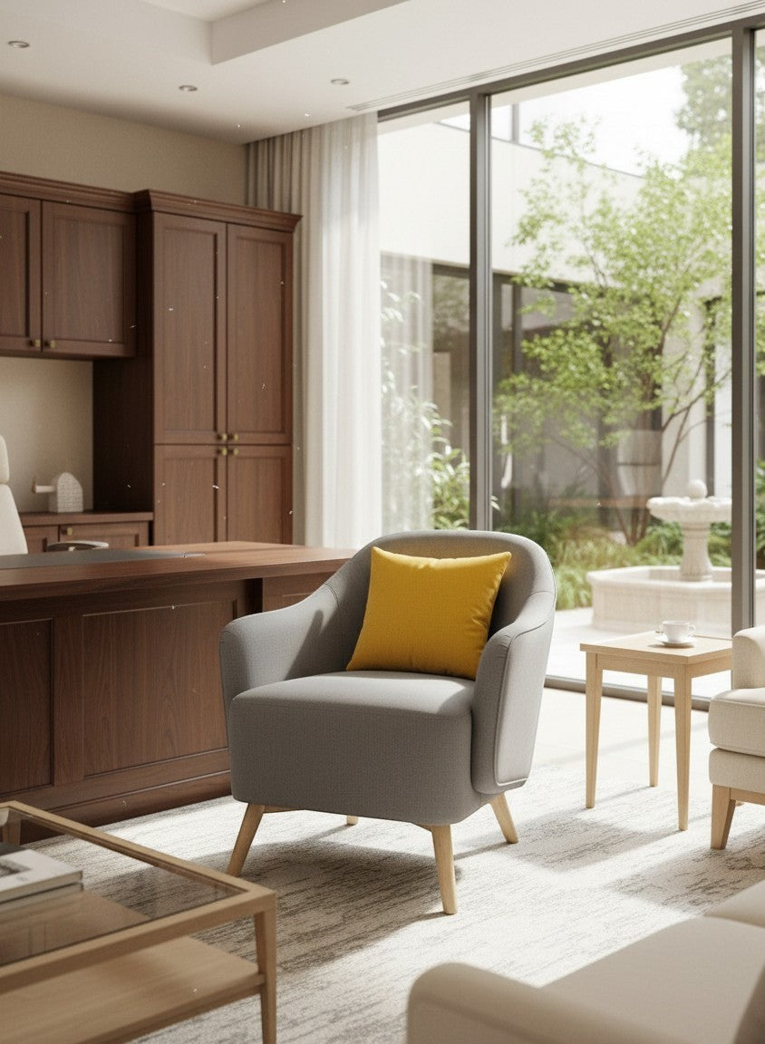 STYLNN® grey curved tub chair with a yellow accent pillow, featuring natural wooden legs in a modern home office.
